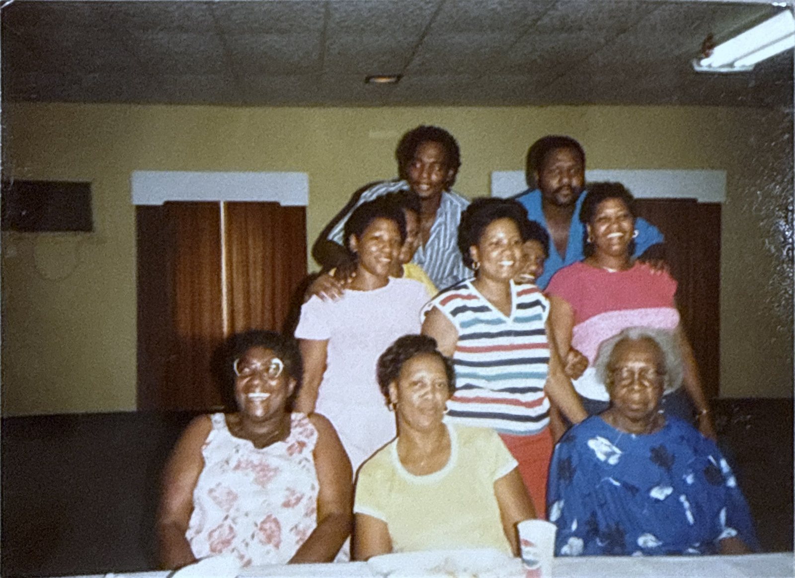 Older family photograph of eleven relatives, women seated in front and young men standing behind