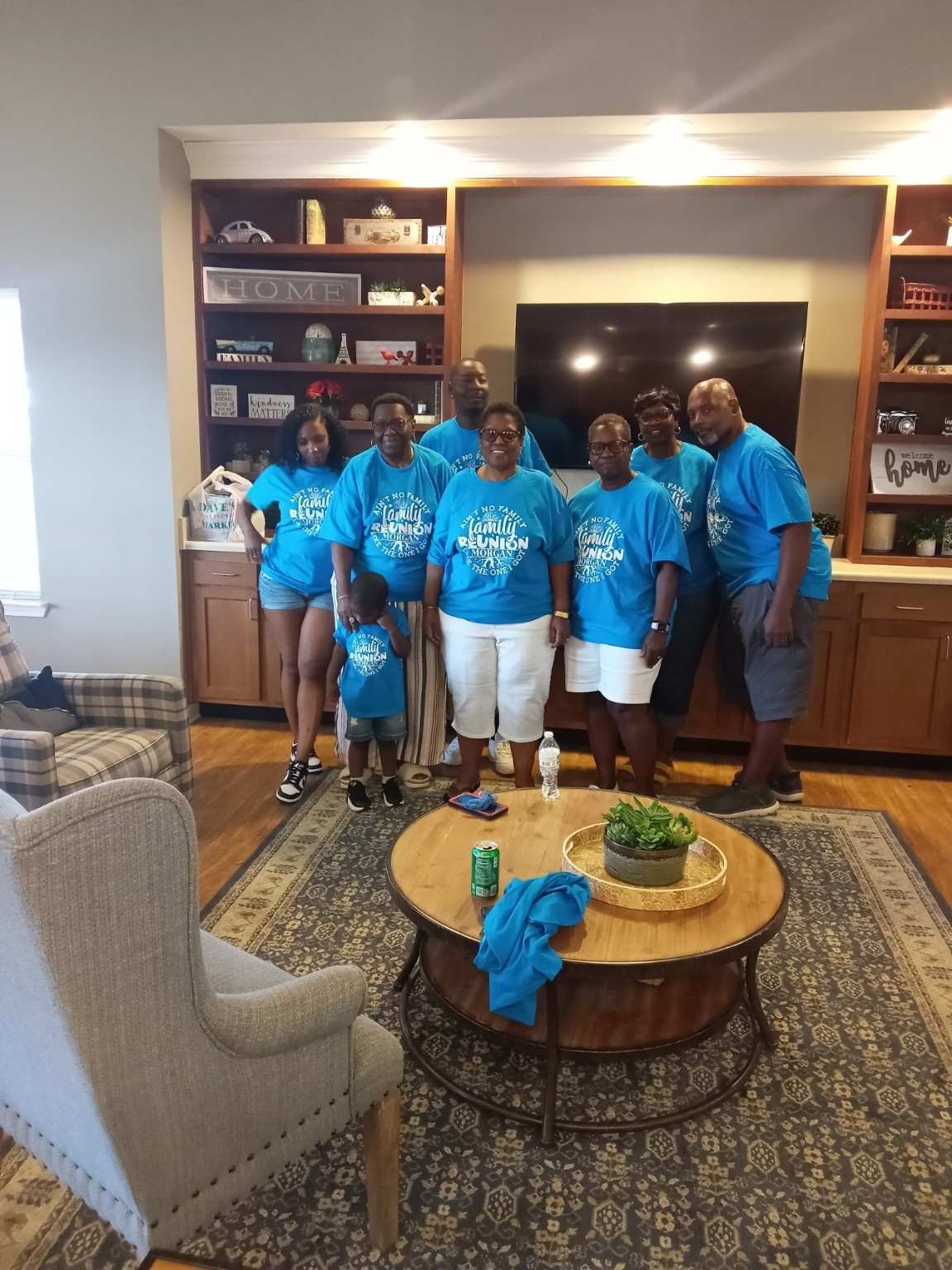 Family members, including a child, gathered in matching blue reunion shirts